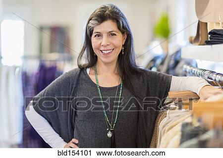 Hispanic small business owner smiling in store View Large Photo Image Stock Image - Hispanic small business owner smiling in store. Fotosearch