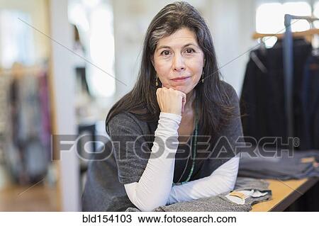 Hispanic small business owner smiling in store View Large Photo Image Stock Image - Hispanic small business owner smiling in store. Fotosearch
