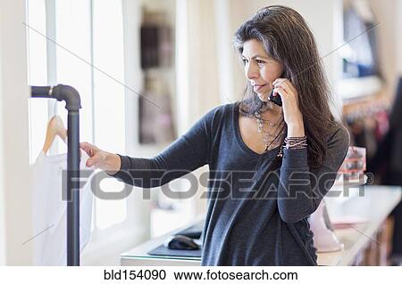 Hispanic small business owner talking on telephone View Large Photo Image Stock Image - Hispanic small business owner talking on telephone. Fotosearch