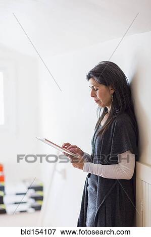 Hispanic small business owner using digital tablet in store View Large Photo Image Stock Photo - Hispanic small business owner using digital tablet in store. Fotosearch