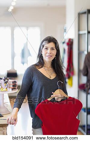 Stock Image - Hispanic small business owner working in store. Fotosearch