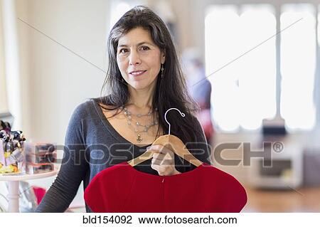 Stock Image - Hispanic small business owner working in store. Fotosearch