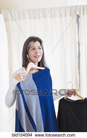 Picture - Hispanic woman browsing clothing in store. Fotosearch