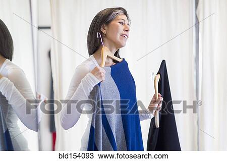 Hispanic woman browsing clothing in store View Large Photo Image Stock Image - Hispanic woman browsing clothing in store. Fotosearch