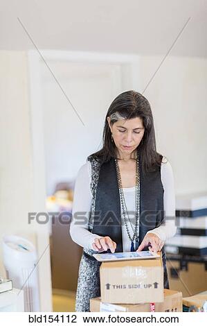 Hispanic woman using digital tablet in office View Large Photo Image Stock Image - Hispanic woman using digital tablet in office. Fotosearch