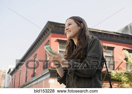 Low angle view of Caucasian woman using cell phone outdoors View Large Photo Image Stock Photo - Low angle view of Caucasian woman using cell phone outdoors. Fotosearch