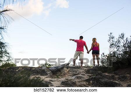 Low angle view of couple enjoying scenic view at beach View Large Photo Image Stock Image - Low angle view of couple enjoying scenic view at beach. Fotosearch