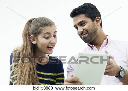 Stock Image - Low angle view of couple using digital tablet. Fotosearch