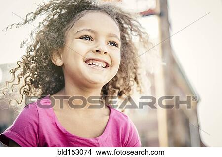 Low angle view of mixed race girl smiling outdoors View Large Photo Image Picture - Low angle view of mixed race girl smiling outdoors. Fotosearch