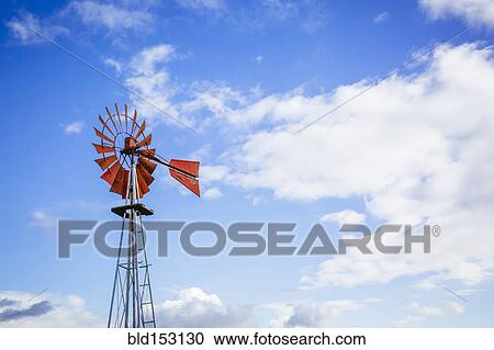 Stock Image - Low angle view of windmill turning under blue sky. Fotosearch