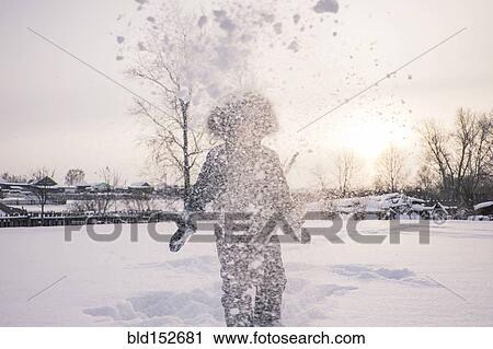 Stock Image - Mari boy in parka playing in snowy field. Fotosearch