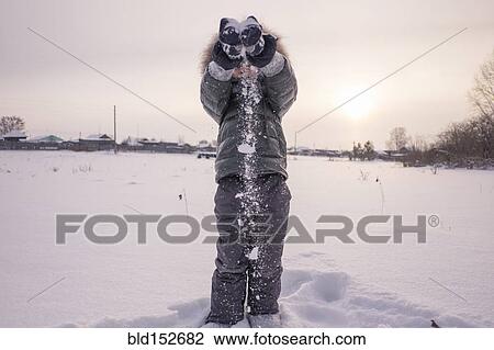Stock Image - Mari boy in parka playing in snowy field. Fotosearch