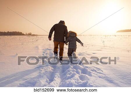 Mari father and son walking in snowy field View Large Photo Image Stock Photo - Mari father and son walking in snowy field. Fotosearch