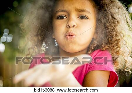 Mixed race girl blowing chalk dust from open palm View Large Photo Image Stock Photo - Mixed race girl blowing chalk dust from open palm. Fotosearch
