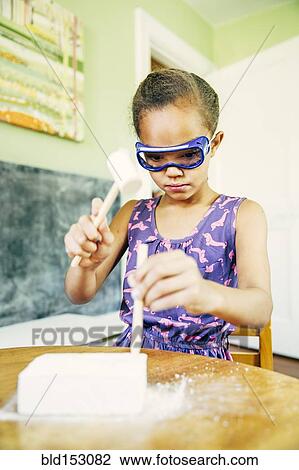 Stock Image - Mixed race girl doing science experiment at home. Fotosearch