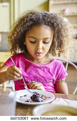Mixed race girl eating dessert in cafe View Large Photo Image Stock Image - Mixed race girl eating dessert in cafe. Fotosearch