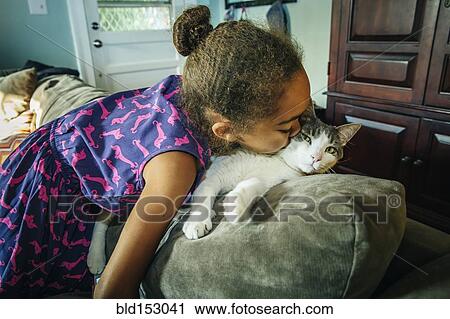 Mixed race girl kissing pet cat on sofa View Large Photo Image Stock Image - Mixed race girl kissing pet cat on sofa. Fotosearch