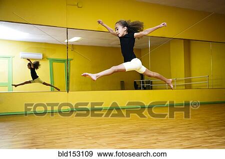 Stock Photo - Mixed race girl leaping in ballet studio. Fotosearch