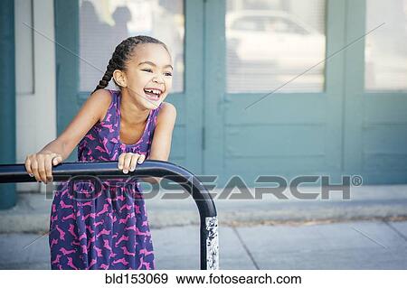 Mixed race girl playing on bicycle rack View Large Photo Image Stock Photo - Mixed race girl playing on bicycle rack. Fotosearch
