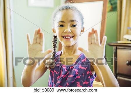 Stock Photo - Mixed race girl showing chalky hands. Fotosearch