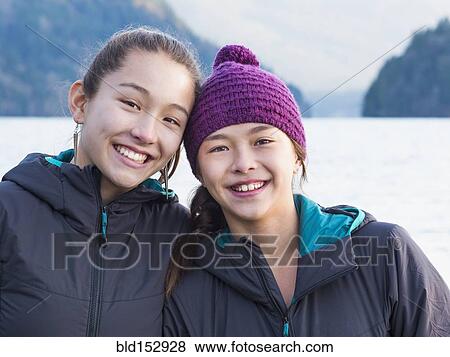Mixed race sisters smiling at lake View Large Photo Image Stock Photo - Mixed race sisters smiling at lake. Fotosearch