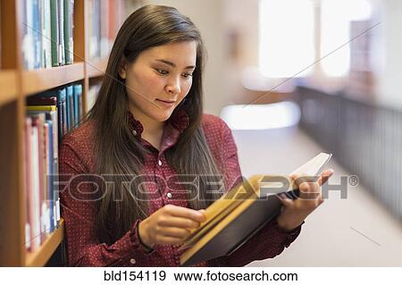 Mixed race student reading in library View Large Photo Image Stock Photo - Mixed race student reading in library. Fotosearch
