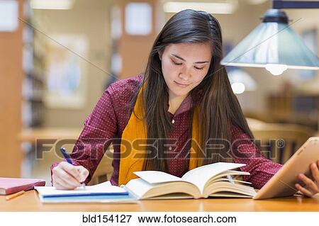 Stock Photo - Mixed race student studying in library. Fotosearch