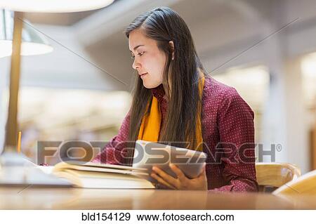 Stock Photo - Mixed race student studying in library. Fotosearch