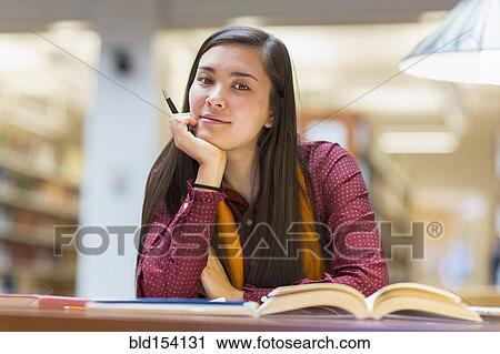 Stock Image - Mixed race student working in library. Fotosearch
