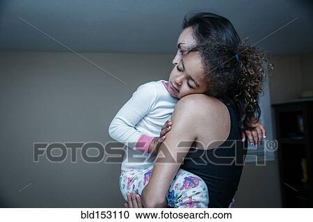 Mother carrying sleepy daughter View Large Photo Image Stock Image - Mother carrying sleepy daughter. Fotosearch