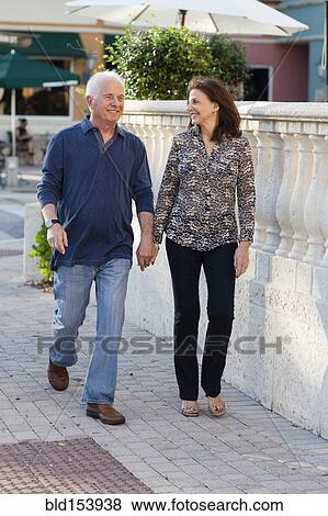Older Caucasian couple holding hands on sidewalk View Large Photo Image Stock Photo - Older Caucasian couple holding hands on sidewalk. Fotosearch