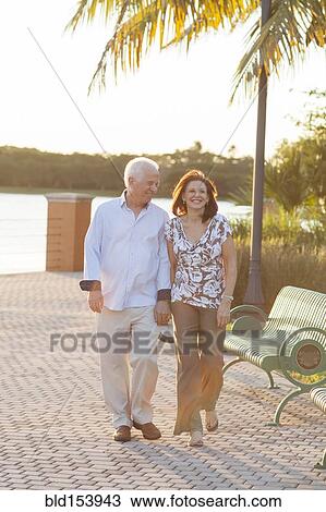 Stock Image - Older Caucasian couple holding hands outdoors. Fotosearch