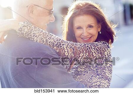 Stock Image - Older Caucasian couple hugging outdoors. Fotosearch