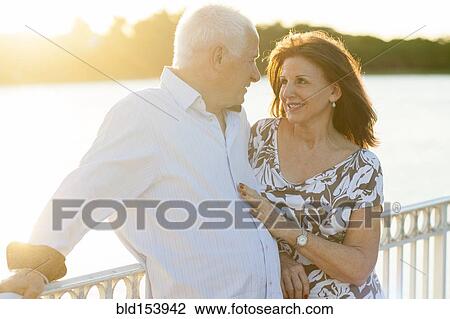 Stock Image - Older Caucasian couple hugging outdoors. Fotosearch