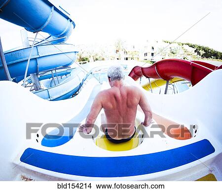 Older Caucasian man sitting on water slide View Large Photo Image Picture - Older Caucasian man sitting on water slide. Fotosearch