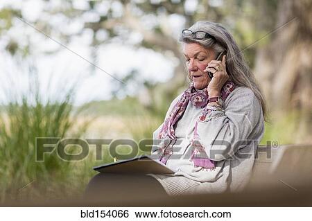 Older Caucasian woman talking on cell phone outdoors View Large Photo Image Stock Photograph - Older Caucasian woman talking on cell phone outdoors. Fotosearch