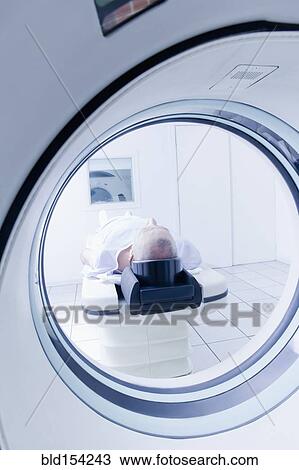 Stock Image - Older Hispanic man laying in MRI scanner. Fotosearch