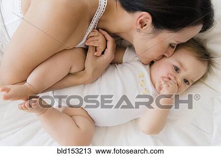 Overhead view of mixed race mother kissing baby on bed View Large Photo Image Stock Image - Overhead view of mixed race mother kissing baby on bed. Fotosearch
