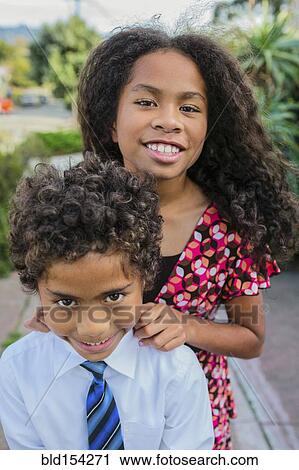 Stock Image - Pacific Islander brother and sister smiling outdoors. Fotosearch