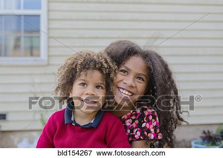Stock Photo - Pacific Islander brother and sister hugging outdoors. Fotosearch