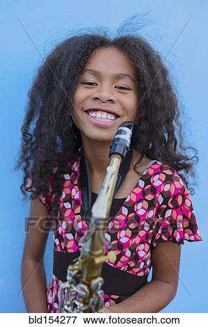 Stock Photo - Pacific Islander girl holding saxophone. Fotosearch