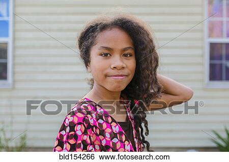 Stock Photograph - Pacific Islander girl smiling outdoors. Fotosearch
