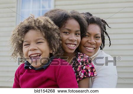 Stock Photo - Pacific Islander mother and children hugging outdoors. Fotosearch
