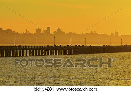 Stock Image - Silhouette of San Francisco city skyline over highway on bay. Fotosearch
