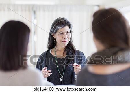 Small business owner talking to customers in store View Large Photo Image Stock Image - Small business owner talking to customers in store. Fotosearch