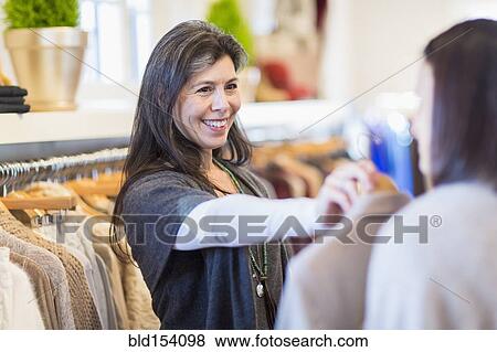 Stock Photo - Small business owner talking to customer in store. Fotosearch