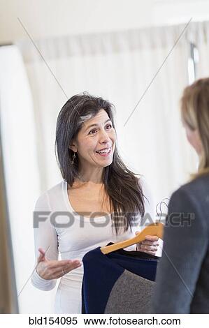 Stock Photography - Small business owner talking to customer in store. Fotosearch