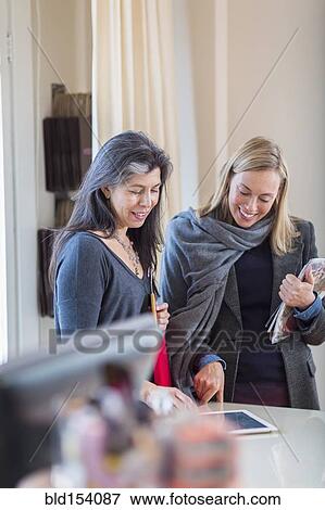 Small business owners using digital tablet in store View Large Photo Image Stock Photo - Small business owners using digital tablet in store. Fotosearch