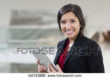 Smiling Hispanic businesswoman holding digital tablet View Large Photo Image Stock Photograph - Smiling Hispanic businesswoman holding digital tablet. Fotosearch
