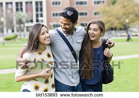 Stock Image - Smiling students walking on campus. Fotosearch